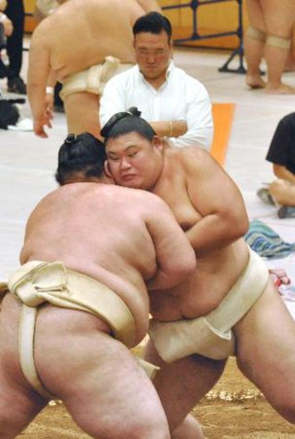 　大相撲夏巡業で熱海富士（左）と相撲を取る大の里。奥は師匠の二所ノ関親方＝茨城県つくばみらい市