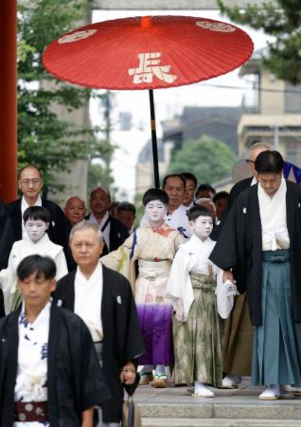 　京都・祇園祭の無事を祈願する「お千度の儀」で、八坂神社を参拝する稚児の長谷航太郎さん（中央）ら＝１日午前、京都市東山区