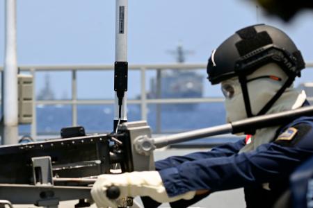 　重機関銃による実弾発射訓練に臨むフィリピン軍の兵士＝２５日、南シナ海洋上（共同）