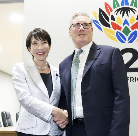 　スターマー英首相（右）と握手する高市首相＝２０２５年１１月、南アフリカのヨハネスブルク（共同）