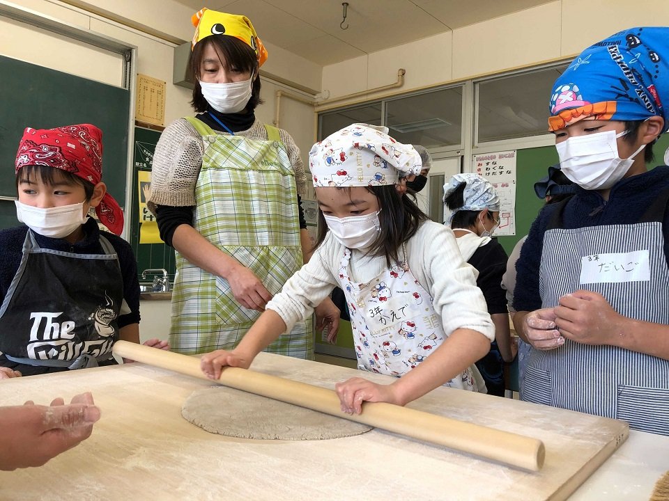棒でそばを延ばす児童＝山県市大桑、大桑小学校
