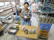 オリジナルの招き猫の絵付けをする熊谷桃子さん＝恵那市明智町、明知製陶
