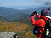 富士見岳頂上で紅葉を写真に収める登山者＝高山市丹生川町、乗鞍岳