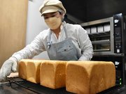 焼きたての食パンを並べる従業員＝羽島市竹鼻町飯柄、今日もひとり占め岐阜羽島店