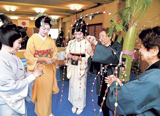 花もち飾り作りに精を出す下呂温泉の芸妓・舞妓と旅館関係者＝下呂市湯之島、下呂温泉旅館会館