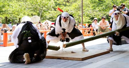 　鞍馬寺の「竹伐り会式」で、大蛇に見立てた青竹をたたき切る僧兵姿の男性＝２０日午後、京都市左京区
