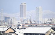 雪化粧した山を背に立つＪＲ岐阜駅周辺のビル＝３０日午前８時２７分、羽島郡笠松町から臨む（撮影・堀尚人）