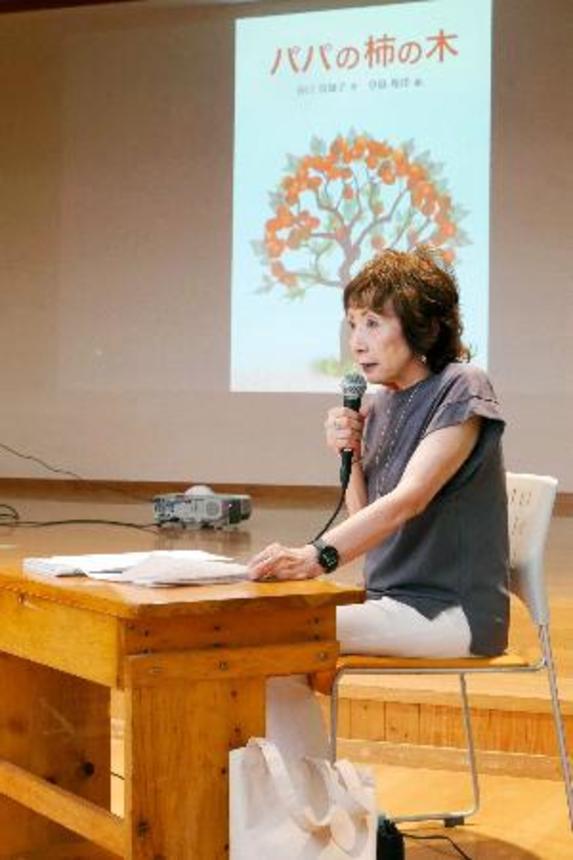 　自作の絵本「パパの柿の木」を朗読する谷口真知子さん＝８日午前、群馬県上野村