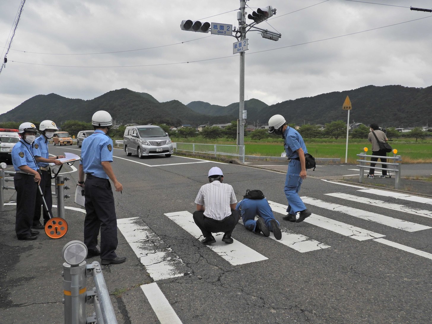 事故現場で実況見分を行う岐阜中署員ら＝３０日午後４時３５分ごろ、岐阜市上芥見