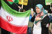 　ワシントンのホワイトハウス前で行われた抗議デモで、イラン国旗を掲げるタヘルさん＝１８日（共同）