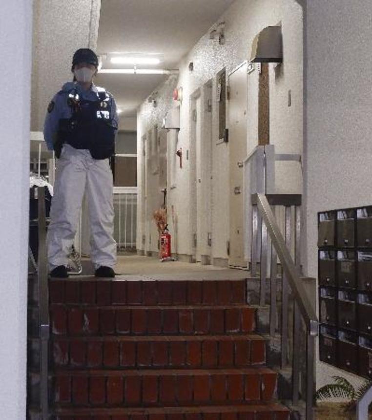 　冷凍庫に入った男性の遺体が見つかった集合住宅を警戒する警察官＝６月２０日、神戸市中央区