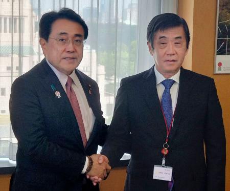 　赤沢経済再生相（左）と握手する日本自動車工業会の片山正則会長＝１７日午前、東京都千代田区