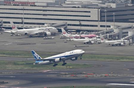 　羽田空港を離陸する全日空機と駐機する日航機＝４日午後（共同通信社ヘリから）