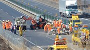 中央自動車道下り線の道路上に散乱した鉄くずなどを撤去する作業員＝２日午前１０時５８分、中津川市千旦林