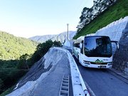 片側交互通行となった箇所を通るバス＝２２日午前７時１分、高山市丹生川町久手