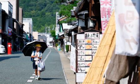　猛暑日となった岐阜県美濃市で日傘を差す児童＝７日午後