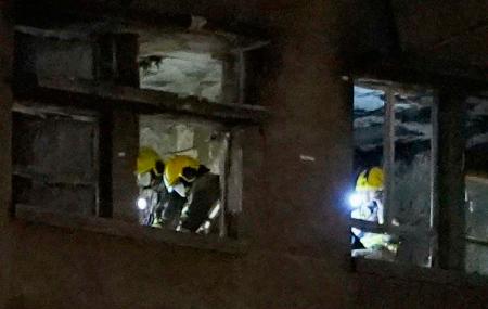 　火災現場の高層住宅で、日没後も続く捜索活動＝２８日、香港北部・新界地区大埔（共同）