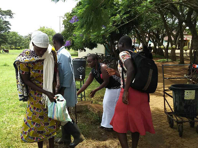 病院のゲートで手洗いをする人々＝ケニア