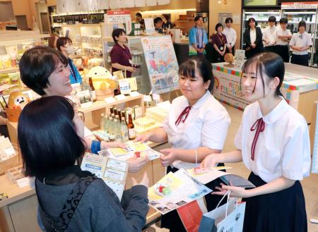 　手作りしたキャンドルを配り、能登への観光をＰＲする「門前学園」の生徒ら＝７日午後、東京・八重洲