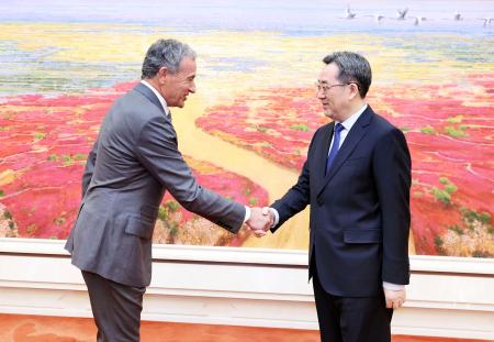 　ウォルト・ディズニーのロバート・アイガーＣＥＯ（左）と握手する中国の丁薛祥筆頭副首相＝９日、北京（新華社＝共同）