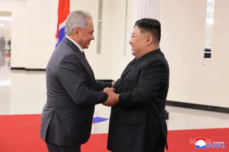　ロシアのショイグ安全保障会議書記（左）と握手する北朝鮮の金正恩朝鮮労働党総書記＝１７日、平壌（朝鮮中央通信＝共同）