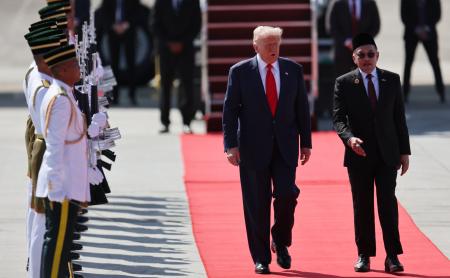 　２６日、マレーシア・クアラルンプールの空港に到着したトランプ米大統領（中央）と共に歩くマレーシアのアンワル首相（右）（ＡＰ＝共同）