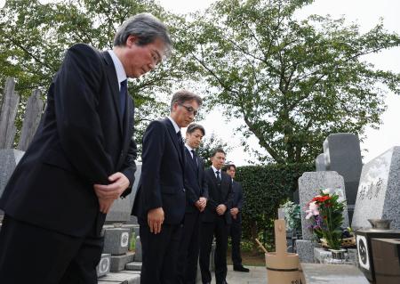 　相嶋静夫さんの墓前で謝罪する（左から）最高検の小池隆公安部長、東京地検の市川宏次席検事、警視庁の鎌田徹郎副総監。奥２人は相嶋さんの息子＝２５日午前、横浜市の霊園（代表撮影、画像の一部を加工しています）
