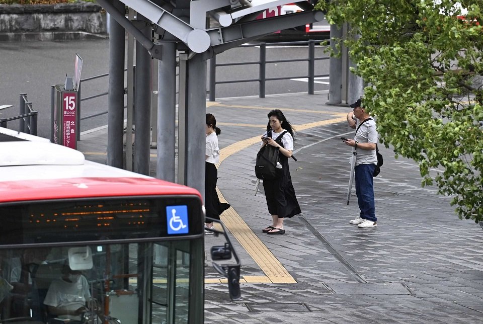 風雨が強まる中、バスを待つ人たち＝１５日午前７時５８分、岐阜市内