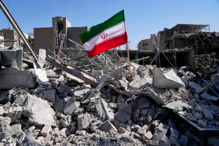 　３日、イランの首都テヘランで、攻撃を受けがれきとなった警察施設に立てられた国旗（ＡＰ＝共同）