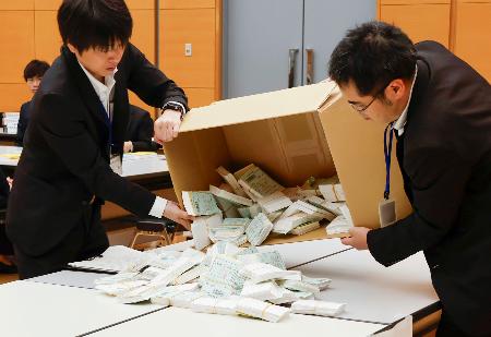 　茨城県神栖市長選を巡り、再点検する票を箱から取り出す職員＝２１日午前、水戸市