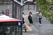風雨が強まる中、バスを待つ人たち＝１５日午前７時５８分、岐阜市内