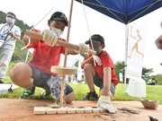 パラリンピック開幕を前にした下呂市の採火式で、聖火になる火をおこす小学生たち＝１２日午前、同市四美、皇樹の杜