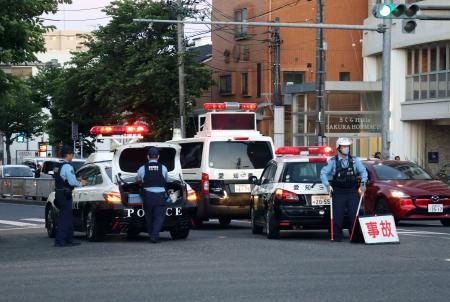 　マイクロバスに歩行者がはねられた交差点を交通規制する警察官＝２９日午後７時７分、名古屋市南区