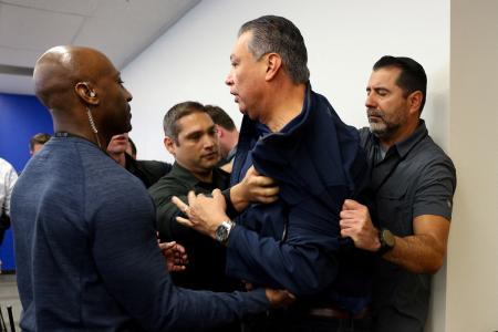 　記者会見場から連れ出されるパディヤ米上院議員（右から２人目）＝１２日、ロサンゼルス（ロイター＝共同）
