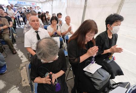　「京橋駅空襲」から８０年となり、ＪＲ京橋駅前で営まれた慰霊祭で、犠牲者を追悼する参列者たち＝１４日午前、大阪市