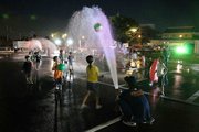 水を浴びながら、ビーチボールを楽しむ子どもたち＝池田町六之井、町中央公民館南駐車場