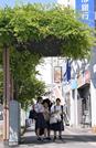 　厳しい暑さとなり日陰で信号待ちする人たち＝３０日午後、埼玉県熊谷市