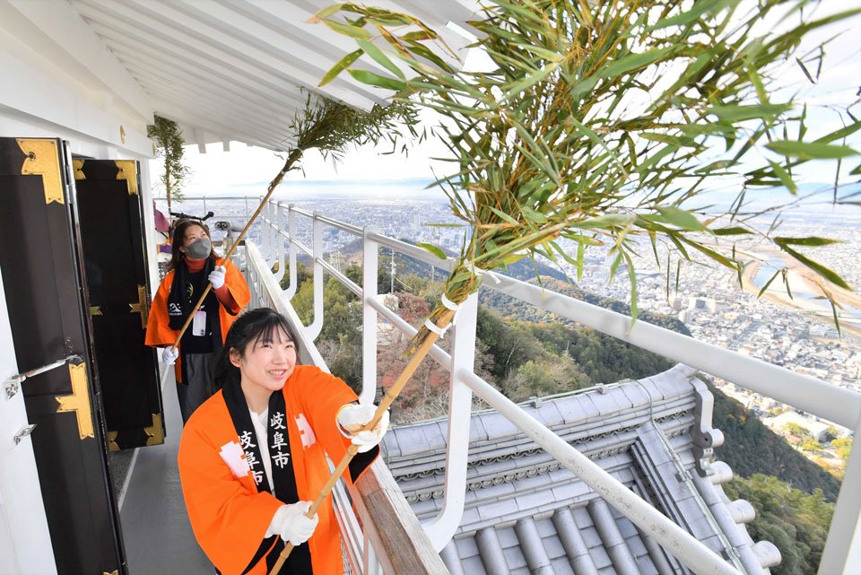 天守の軒裏のすすを払う参加者＝１３日午前１０時４９分、岐阜市、金華山山頂の岐阜城