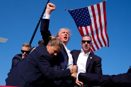 　昨年７月、選挙集会で銃撃を受け、大統領警護隊に囲まれながら拳を上げるトランプ氏＝米ペンシルベニア州バトラー（ＡＰ＝共同）