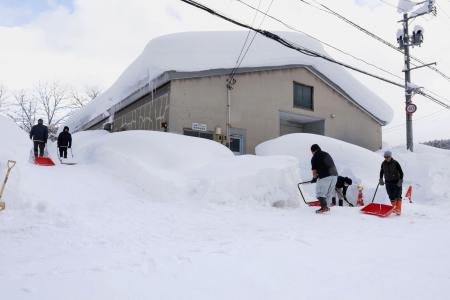 　建物の周囲を除雪する人たち＝２日、青森市
