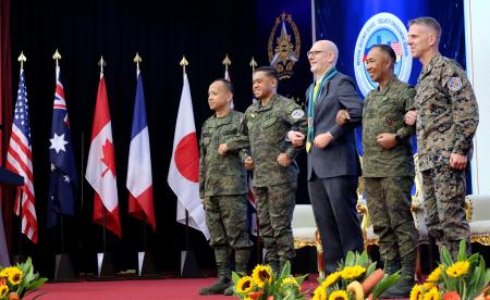 　大規模合同演習「バリカタン」の開幕式で、腕を組んで連帯を表す米国とフィリピンの軍高官ら＝２０日、マニラ（共同）