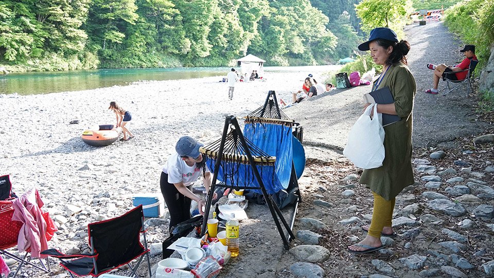 バーベキューを楽しむ人にごみの持ち帰りを呼びかける小椋唯さん（右）＝美濃市長瀬、板取川
