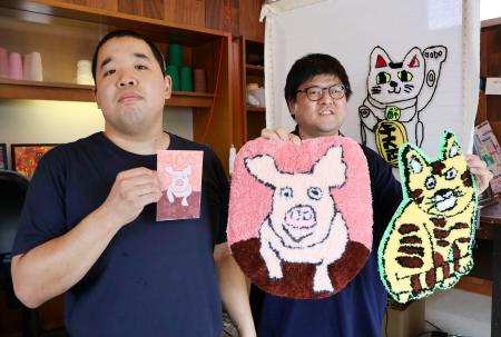 　ラグマットを持つ畠中卓哉さん（右）とデザイン担当者＝７月、福井県小浜市