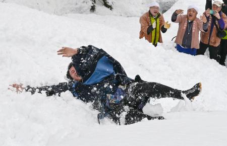 　奇祭「むこ投げ」で雪の斜面に投げ落とされ転がる俵山舜平さん＝１５日午後、新潟県十日町市