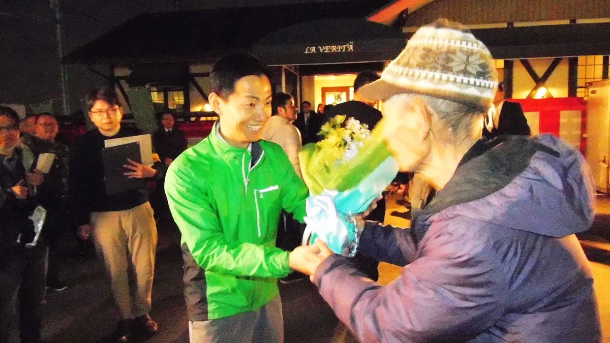 支持者から花束を贈られ握手する藤井浩人さん＝１８日午後５時５５分、美濃加茂市新池町、選挙事務所前