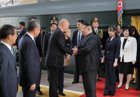 　北京に到着し、中国の最高指導部メンバーと握手する北朝鮮の金正恩朝鮮労働党総書記（右から３人目）。同２人目が娘＝２日（朝鮮中央通信＝共同）