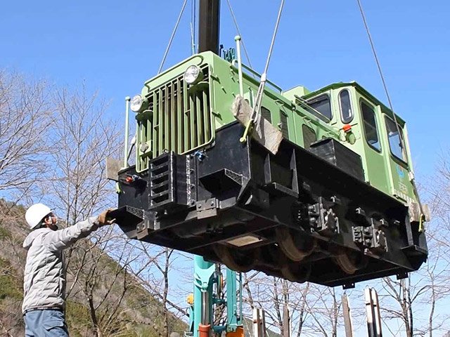クレーンでつり上げられる立山砂防事務所からの機関車＝同