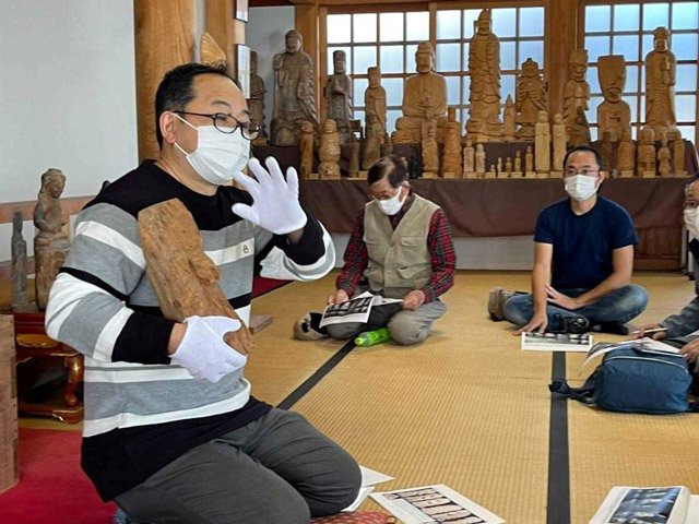 円空仏巡りのツアー中、円空について熱を込めて語るガイド＝関市池尻、弥勒寺