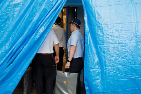 　家宅捜索のため、谷本将志容疑者が勤務していた会社にある社員寮の自室に向かう捜査員＝２７日午前５時１８分、東京都新宿区