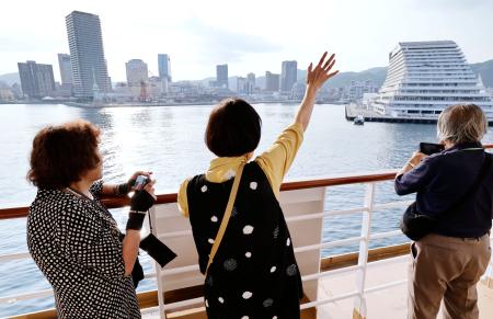 　神戸港を出港し、見送りの人たちに手を振る「洋上慰霊」の参加者＝１日午後